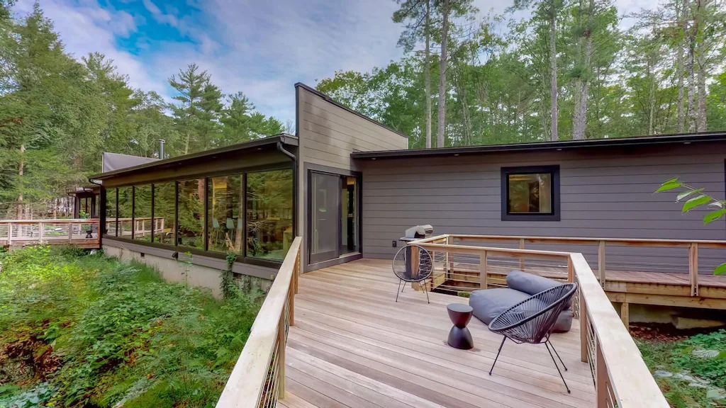 Modern looking cabin with deck in the woods