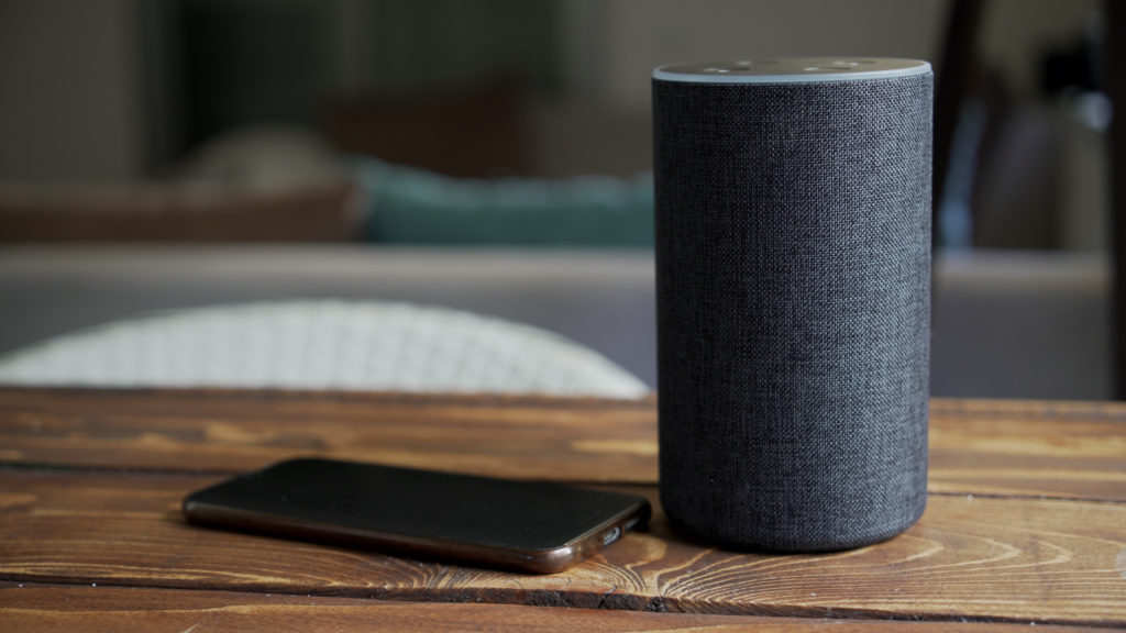 Amazon Echo and smartphone on wooden table
