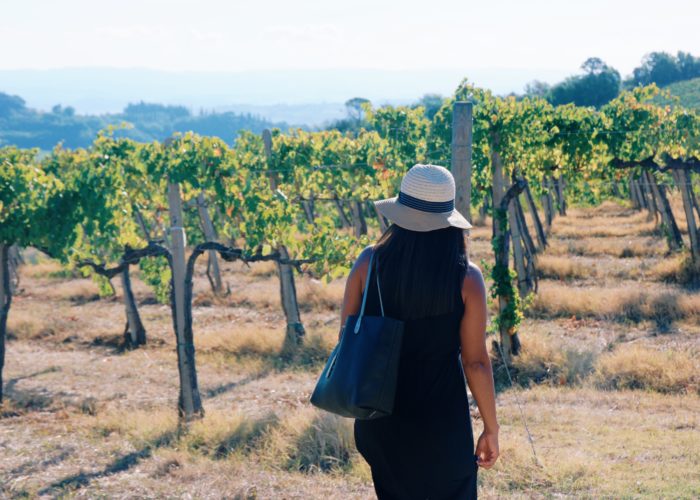 Woman walking through vineyard in Tuscany, Italy